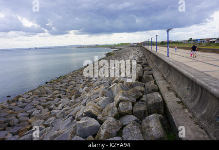 Menschen zu Fuß entlang der Promenade und Meer Barrieren an Seaton Carew Hartlepool Stockfoto