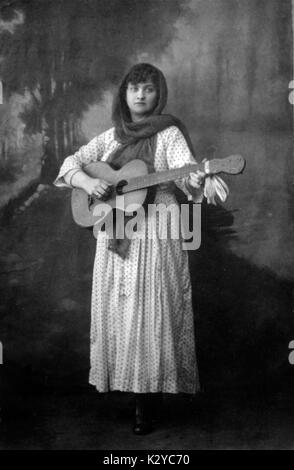 Frau vor gemalten Hintergrund, der Besitz einer Gitarre. Stockfoto