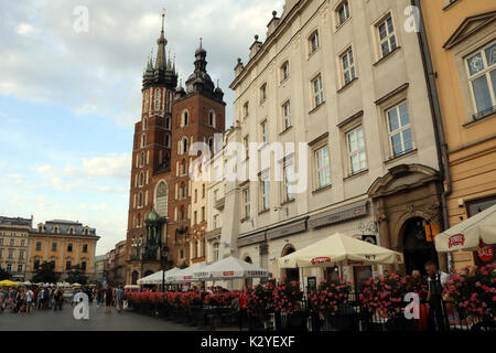 Die Basilika St. Maria am Rynek Glowny, der Hauptplatz in der Altstadt von Krakau, Polen, am 25. August 2017. Szara Restaurant ist im Vordergrund. Stockfoto