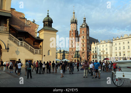 Touristen Spaziergang durch Rynek Glowny, der Hauptplatz in der Altstadt von Krakau, Polen, am 25. August 2017. Die Basilika St. Maria ist im Hintergrund. Stockfoto