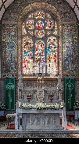 Galway, Irland - August 5, 2017: Chor mit aufwändigen historischen und neuen nüchtern Altar vor lackiert und gebeizt Fenster Kulisse in St. Mary's Ch Stockfoto