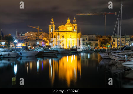 Die schöne Msida Pfarrkirche in tiefe Nacht mit Hafen im Vordergrund. Malta. Stockfoto