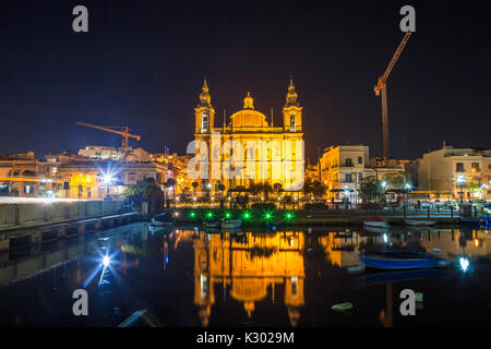 Die schöne Msida Pfarrkirche in tiefe Nacht mit Hafen im Vordergrund. Malta. Stockfoto