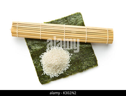 Grüne nori Blatt, Reis und Bambus Matte auf weißem Hintergrund. Sushi Zutaten. Stockfoto