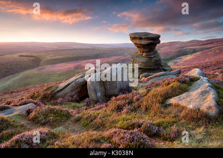 Einen atemberaubenden Sonnenuntergang über der Leiste Keller einer verwitterten Felsformation auf Derwent Kante hoch über teh Ladybower Reservoir in der oberen Derwent Valley in der Stockfoto