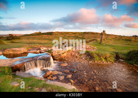 Schönen Abend licht am windigen Post und alten Granit Kreuz auch als Beckamoor Kreuz auf Dartmoor Nationalpark in Devon bekannt Stockfoto