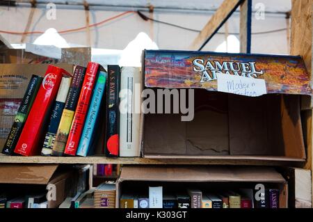 Ein Regal von gebrauchten Bücher zum Verkauf lehnte sich gegen eine leere Bier falle, mit der Aufschrift 'Modern Fiktion, während Baltimore Book Festival, Baltimore, Maryland, September, 2013. Stockfoto
