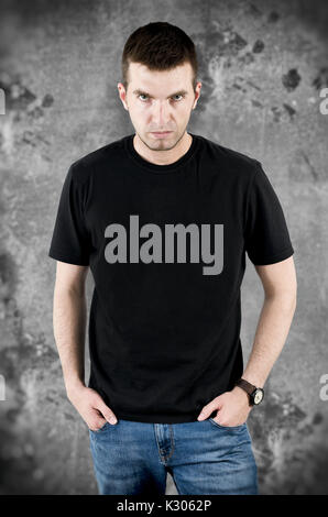 Wütend gefährlicher Mann in schwarzen T-Shirt Vorlage für Ihr Projekt. Mann auf grunge Hintergrund Stockfoto