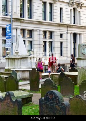 Die Trinity Church, Wall Street und Broadway, New York, USA. Familie sucht auf Grabsteinen, darunter Alexander Hamilton's, in der Dreiheit Kirchhof. Stockfoto