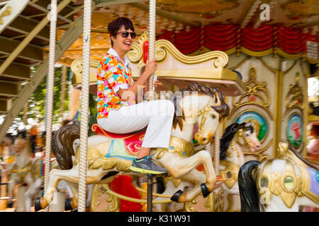 Frau reiten Traditionelle gallopers auf eine Karussellfahrt, Santander. Kantabrien Spanien, Europa Stockfoto