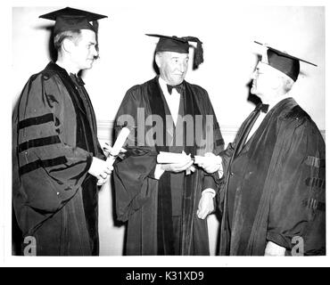 Amerikanische Geograph und Präsident der Johns Hopkins University Jesaja Bowman stellt Grad auf britische Diplomat Archibald Clark Kerr 1 Baron Inverchapel und amerikanische Regierungsbeamte Alger Hiss auf Johns Hopkins University Gedenktag, feiert die Gründung der Universität in Baltimore, Maryland, 22. Februar 1947. Stockfoto