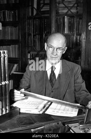 Ein Porträt von Professor der Ingenieur bei Wittling Schule der Technik Alexander Graham Christie in seinem Büro vor eine Mappe voller Papiere, der 64 Jahre an der Johns Hopkins University, Baltimore, Maryland, 1955. Stockfoto