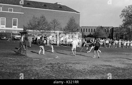 Graustufen Aktion Foto während der Männer lacrosse Praxis an der Johns Hopkins University, mit den Spielern, die in Shorts und T-Stücke, wie sie in Richtung auf das Ziel ausgeführt werden, und einer langen Reihe von Zuschauern am unmittelbaren Nebenerwerb stehend, Baltimore, Maryland, 1951. Stockfoto