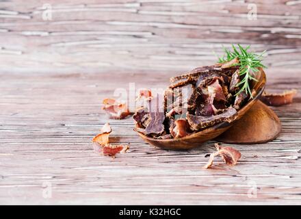 Carded Fleisch, Rind, Hirsch, wildes Tier oder biltong in hölzernen Schüsseln auf rustikalem Tisch, selektiven Fokus Stockfoto