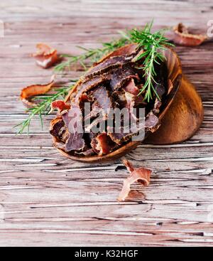 Carded Fleisch, Rind, Hirsch, wildes Tier oder biltong in hölzernen Schüsseln auf rustikalem Tisch, selektiven Fokus Stockfoto