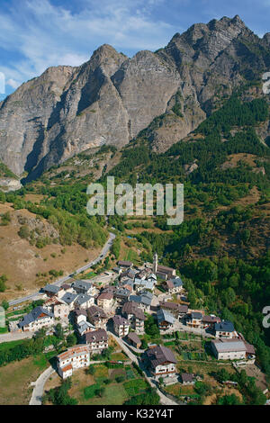 LUFTAUFNAHME. Kleines abgelegenes Dorf am Fuße einer massiven Klippe. Pontebernardo, Stura di Demonte, Provinz Cuneo, Piemont, Italien. Stockfoto