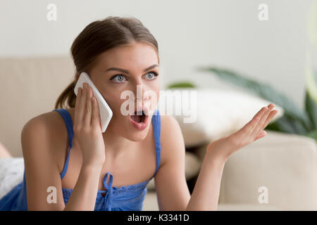 Überrascht junge Frau Gespräch am Handy Stockfoto