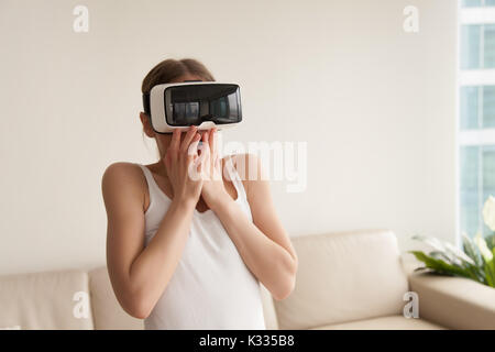 Frau in VR-Headset erschrocken, weil realistische Effekte. Stockfoto