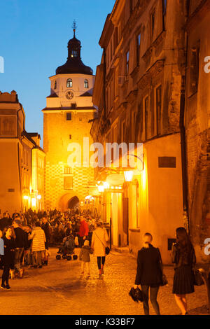 Einheimische, Besucher und Urlauber zu Fuß am Abend in der Altstadt von Lublin entfernt. Die Krakauer Tor ist im Hintergrund. Stockfoto