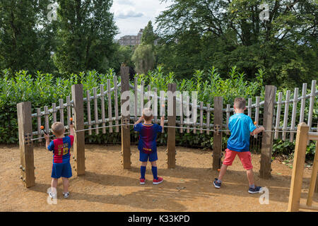 Jungen Jungen experimentieren mit Streik sound Rohre Noten in der Horniman Museum Sound Garden, am 24. August 2017, Forest Hill, London, England. Stockfoto