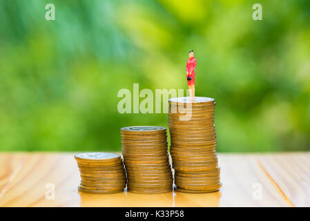 Kleine Leute, kleine Figuren Geschäftsfrau auf Münzen. Geld und finanzielle, Unternehmenswachstum Konzept. seichte Fokus in Weichen. Stockfoto