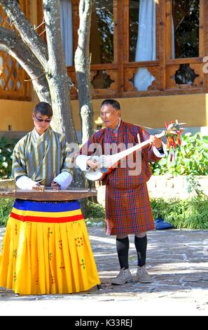 PARO, BHUTAN - November 10, 2012: Unbekannter Musiker in traditioneller Kleidung (GHO) spielen Instrumente im Hotel in Paro, Bhutan Stockfoto