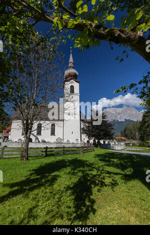 Typische Kirche alpinen Dorfes umgeben von Gipfeln und Wald Garmisch Partenkirchen Oberbayern Region Bayern Deutschland Europa Stockfoto