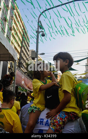 Kinder auf der Schulter des Vaters Ansehen eines brasilianischen Fußball auf der großen Leinwand, Rio de Janiero Stockfoto