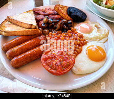 Traditionelles Englisches Frühstück. Gebratene Eier, gebackene Bohnen, Speck, Würstchen und Toast Stockfoto