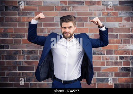 Ein Foto der junge Unternehmer tragen Marine. Er steht im Strongman's darstellen. Stockfoto