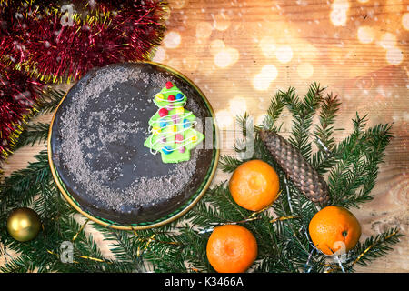 Auf einer hölzernen Tisch perfekt Dekorationen und Geschenke für Weihnachten, Silvester eingestellt ist Kiefer Zweige, Kegel, glänzenden Kugeln, Kuchen, Konfetti. Stockfoto