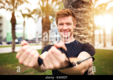 Ein Foto der Jungen, glücklicher Mann Übungen mit Widerstand Band. Stockfoto