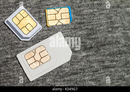 Satz von Mini, Mikro und Nano-SIM-Karte. Auf grauen Tuch Textur Hintergrund isoliert Stockfoto