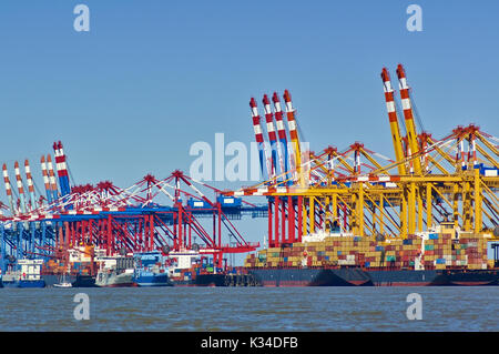 Bunte Hafenanlagen mit Kräne, Container- und Frachtschiffe Stockfoto