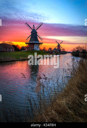 Die berühmten Twin Mühlen von Greetsiel, Ostfriesland bei Sonnenaufgang Stockfoto