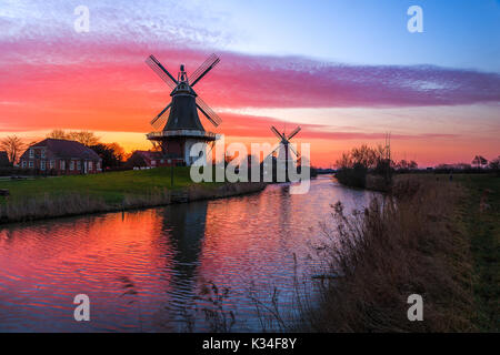 Die berühmten Twin Mühlen von Greetsiel, Ostfriesland bei Sonnenaufgang Stockfoto