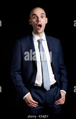 Überrascht Mann auf schwarzen Hintergrund. Augen und Mund weit geöffnet. Stockfoto