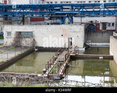 Fabrikgebäude mit Wasserbehälter. Tageslicht, bewölkter Himmel, die Website von Chemikern aus den 70er bis 90er Jahre. Chemische Industrie für Pharmazeutika. Stockfoto