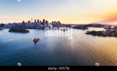 Farbenfroher Sonnenuntergang über die Stadt Sydney CBD und Hafen Wahrzeichen in erhöhten Luftaufnahme über Hafen Wasser. Stockfoto