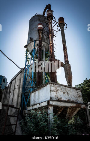 Eine alte und rostige Anlage für das Mischen von Beton Produktion gegen den blauen Himmel, ein grunge Effekt. Stockfoto