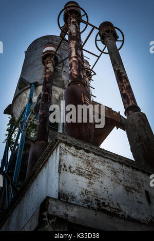 Eine alte und rostige Anlage für das Mischen von Beton Produktion gegen den blauen Himmel, ein grunge Effekt. Stockfoto