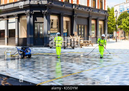 Straßenreinigung mit Druckschläuche in "Navigator Square", Entfernen von Kaugummi aus dem Neu - Fußgängerzone im Zentrum von Torbogen, nördlich von London, Großbritannien Stockfoto