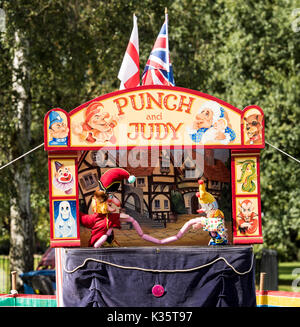 Ein traditionelles Kasperletheater von David Wilde in einem englischen Park im Sommer in Brentwood, Essex mit dem Mr Punch, Clown und Würstchen Stockfoto