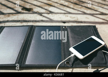 Handy aufladen Über das Solarmodul. Moderne alternative Energiekonzept Stockfoto