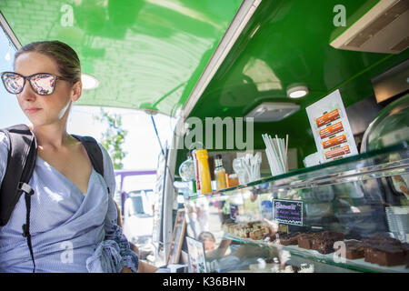 In Merida, Spanien - 14. Mai 2017: Junge attraktive Frau bestellen Essen im Grünen essen Lkw, in der historischen Stadt von Mérida, Extremadura, Spanien Stockfoto