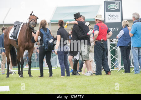 Stamford, Lincolnshire, Großbritannien. 1. September 2017. Burghley Horse TrialsMark Todd steigt von seinem Pferd nach Abschluss in der Dressur und gratuliert durch andere Kredite: Steve Brownley/Alamy leben Nachrichten Stockfoto