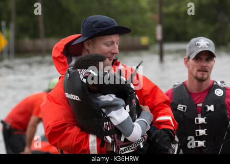 Beaumont, United States. 30 Aug, 2017. Us Coast Guard Personal tragen ein Kind ein CBP-Hubschrauber zur Evakuierung in der Nachmahd des Hurrikans Harvey 30. August 2017 in Beaumont, Texas. Credit: Planetpix/Alamy leben Nachrichten Stockfoto