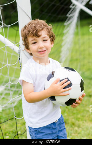 Junge mit Fußball auf einem Feld Spaß Stockfoto