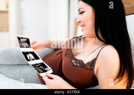 Schwangere Frau von Scan von Baby suchen Stockfoto