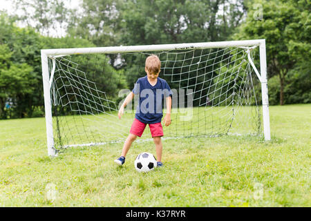 Junge mit Fußball auf einem Feld Spaß Stockfoto